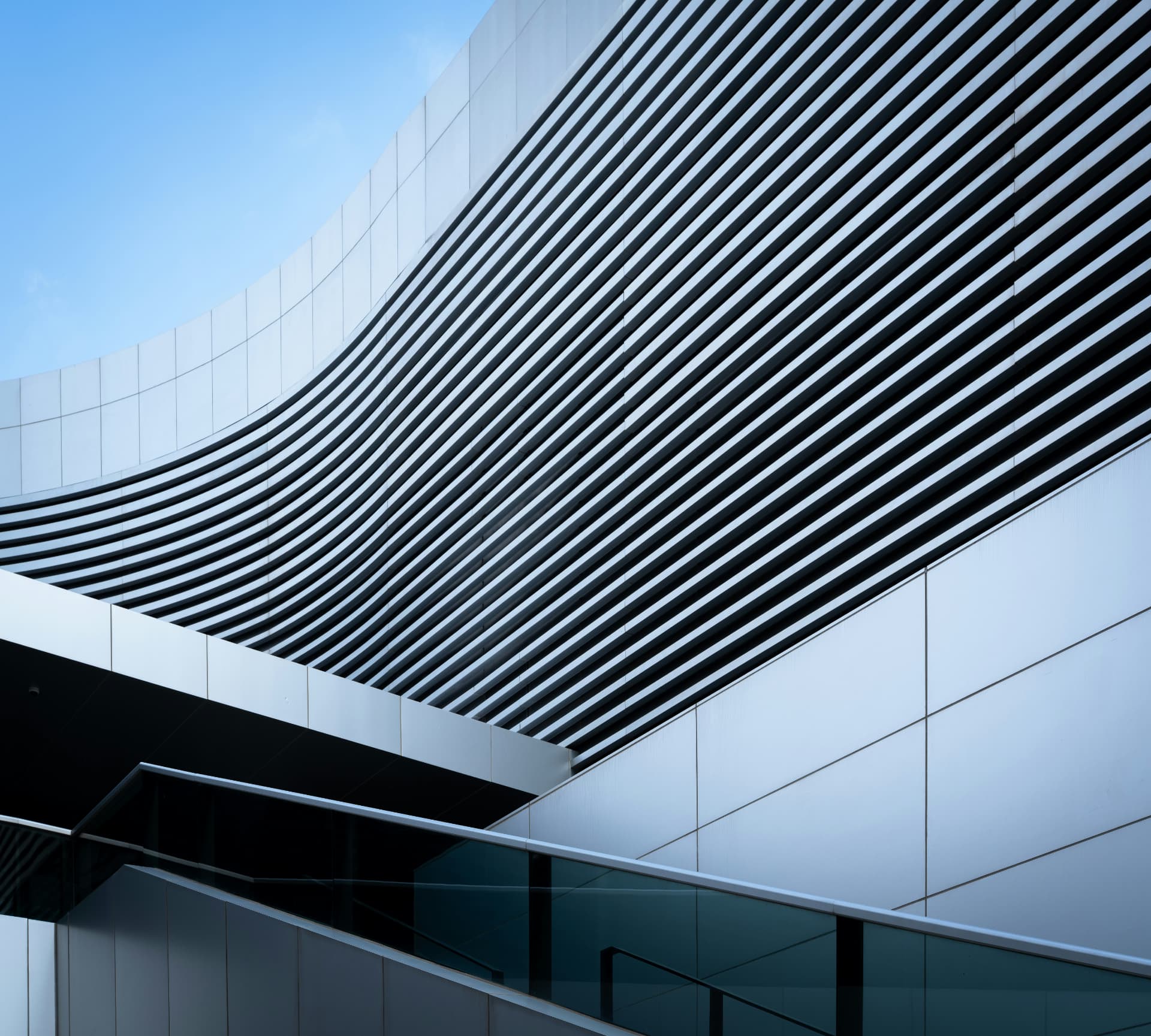 Modern architecture with sweeping curved louvers and geometric linear patterns